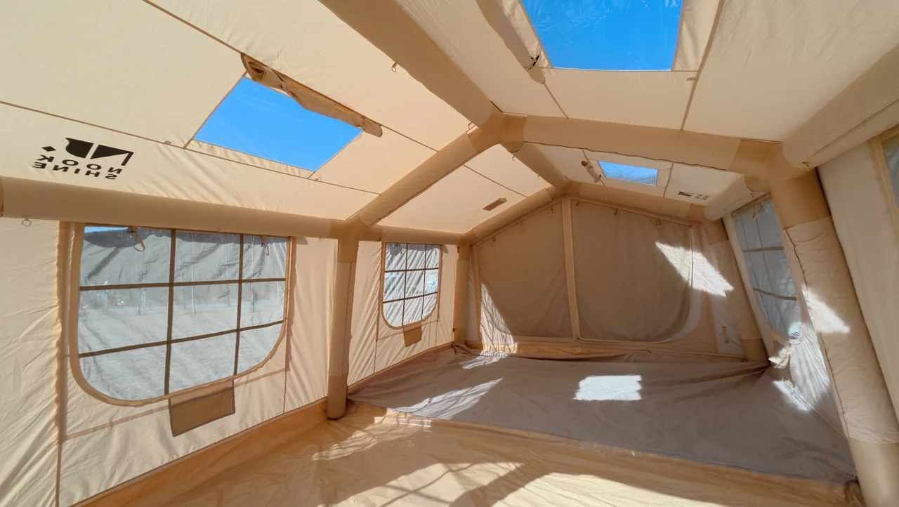 Open interior of a large inflatable lodge showing windows, skylights and floor space