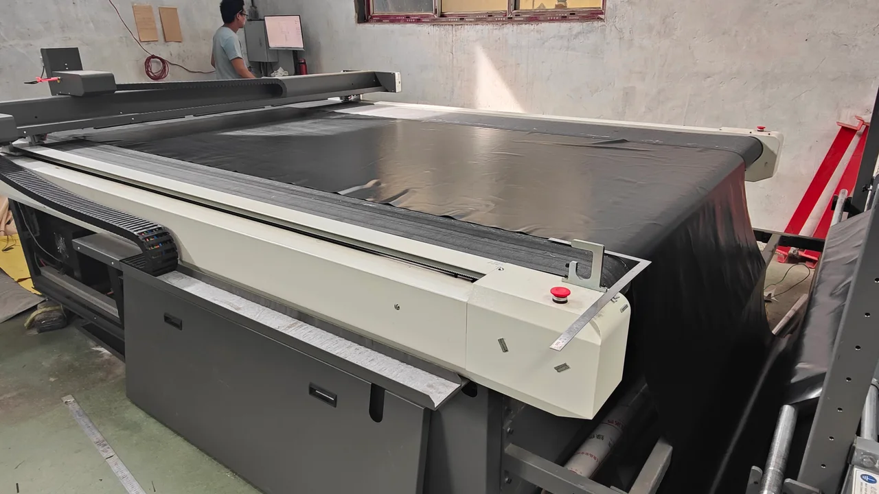 Digital cutting table preparing dark coated material for inflatable tent components
