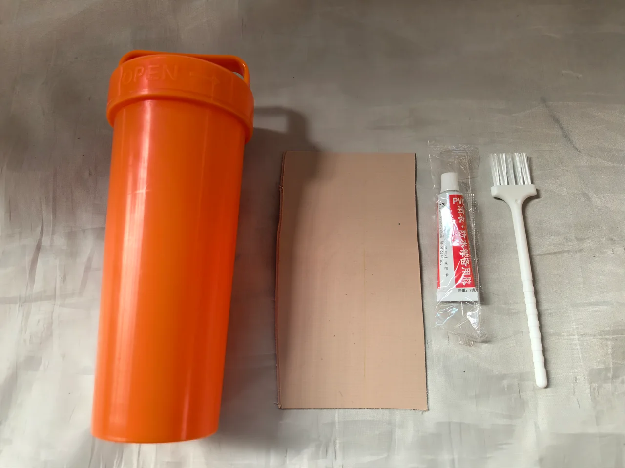 Inflatable tent repair container, patch material, adhesive and brush
