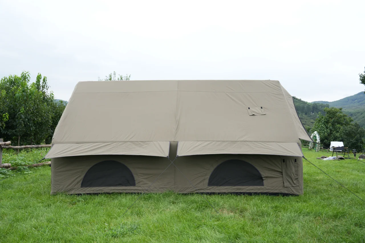 Long side of an olive 12 square metre inflatable lodge with two low covered openings