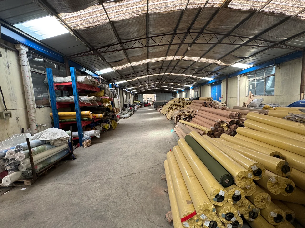 Rows of material rolls stored inside the tent factory