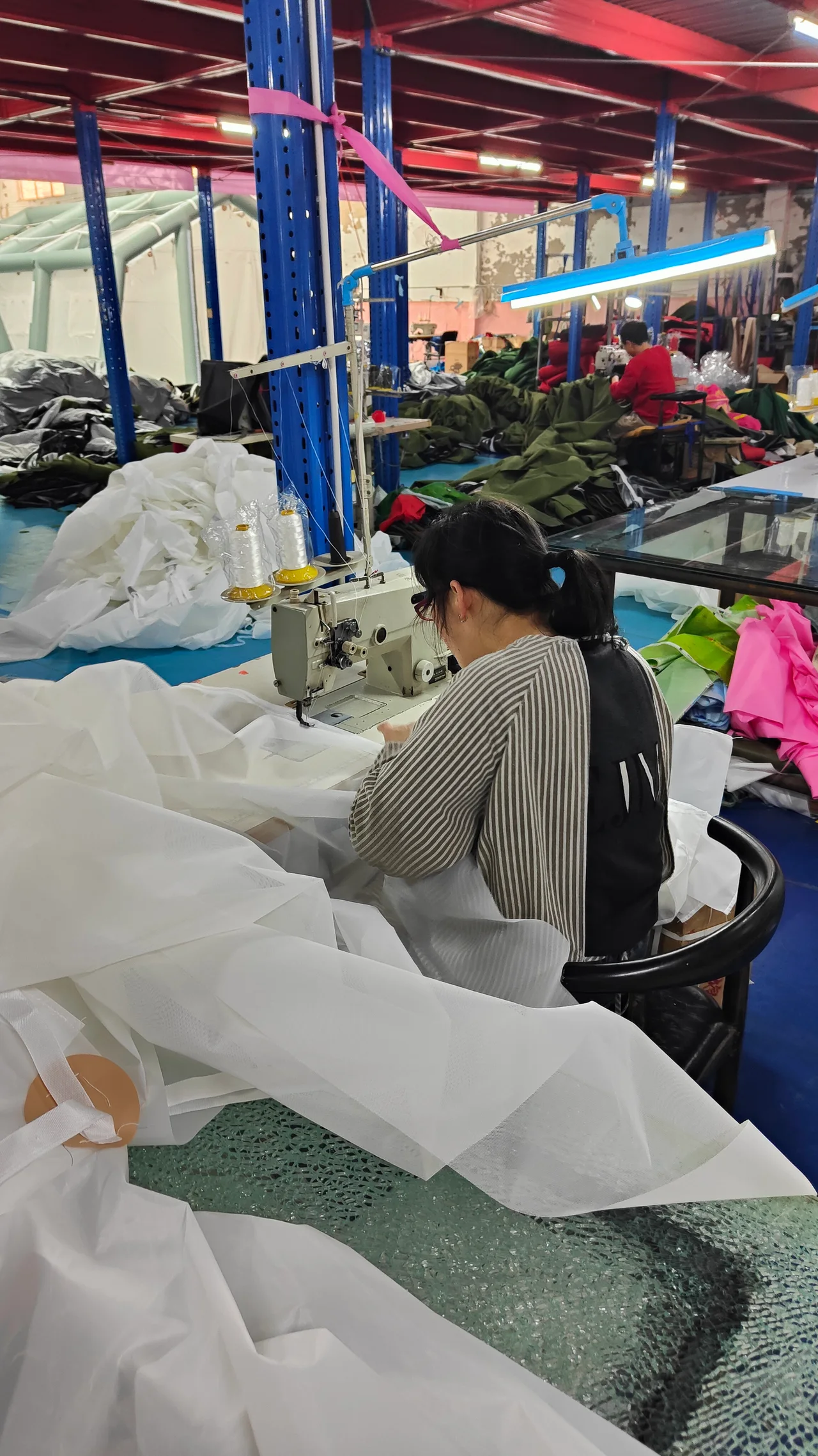 Operator sewing an inflatable tent cover in the factory
