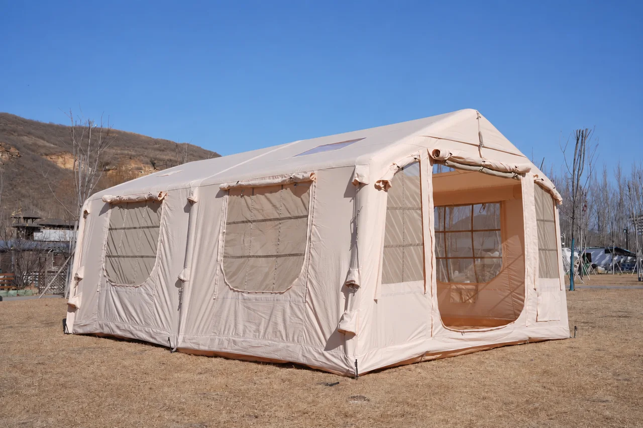 Large beige inflatable glamping lodge with its entrance and side windows open
